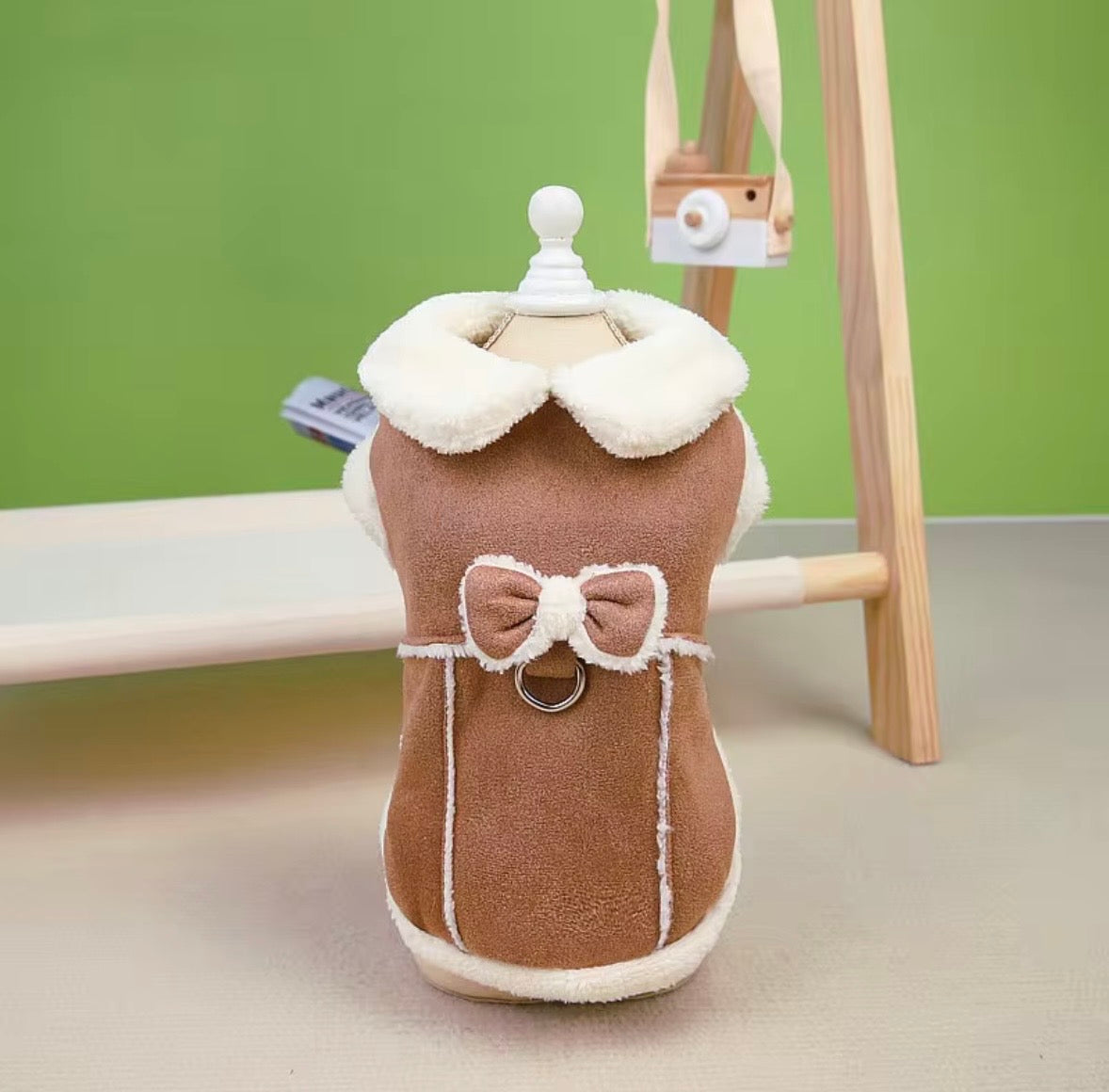 Jecikelon brand beige suede winter coat for small dogs featuring a white fleece lining, turtleneck collar, and decorative bow tie.