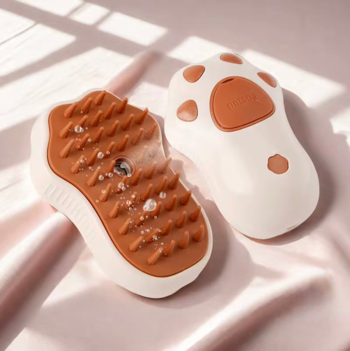 3-in-1 electric steamy pet grooming brush, featuring a rechargeable design with a khaki handle and orange silicone bristles.