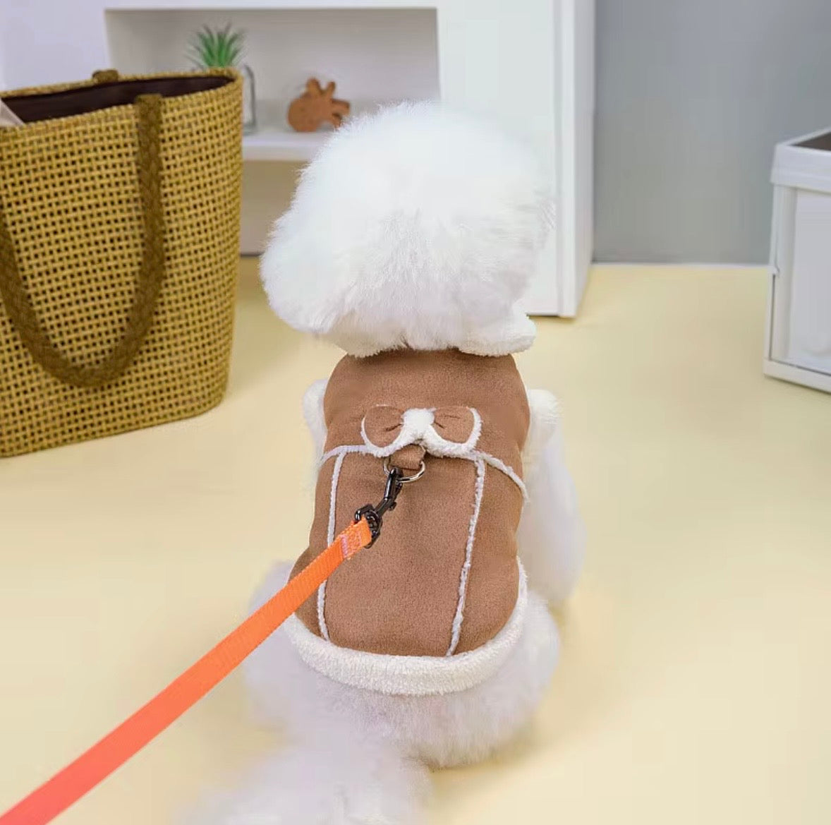 Jecikelon brand beige suede winter coat for small dogs featuring a white fleece lining, turtleneck collar, and decorative bow tie.