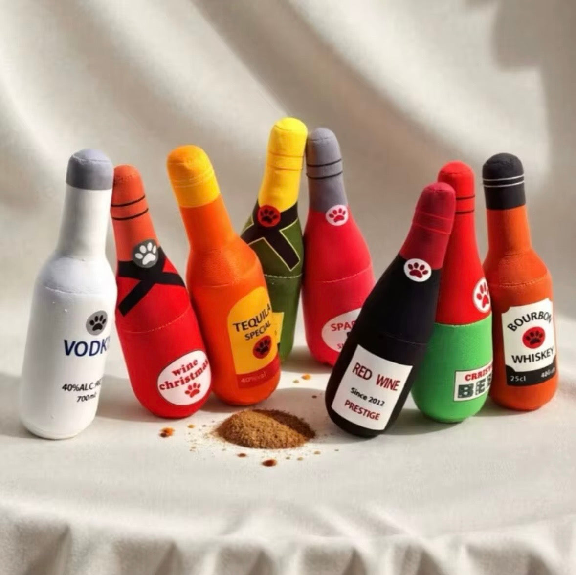 plush, squeaky bottle-shaped toys designed for dogs and cats, featuring various liquor and wine brand parodies.
