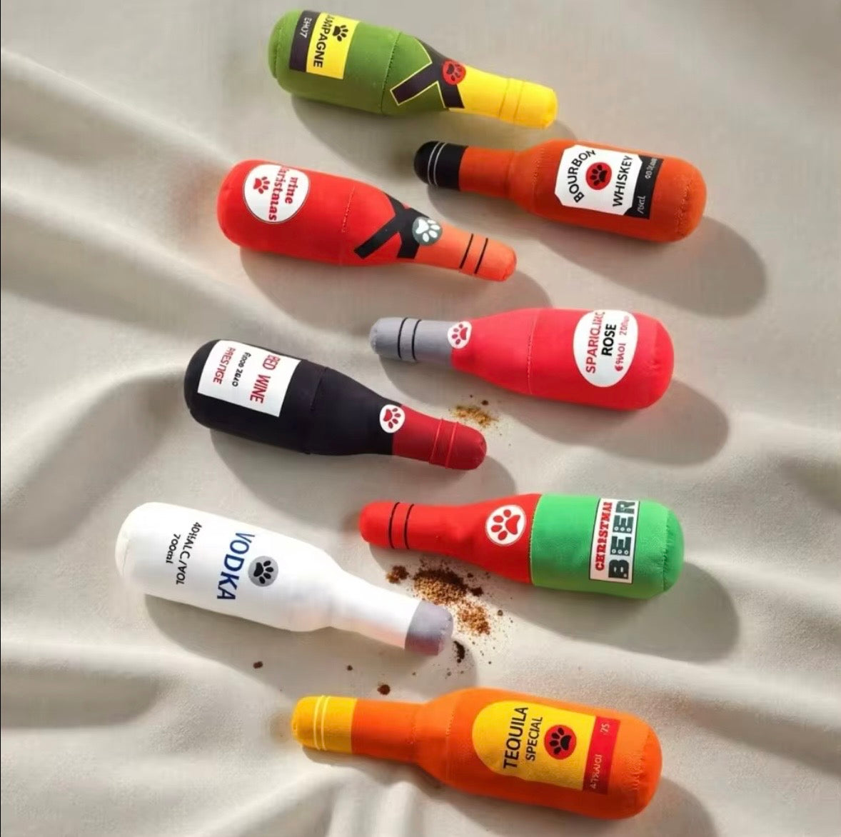 plush, squeaky bottle-shaped toys designed for dogs and cats, featuring various liquor and wine brand parodies.