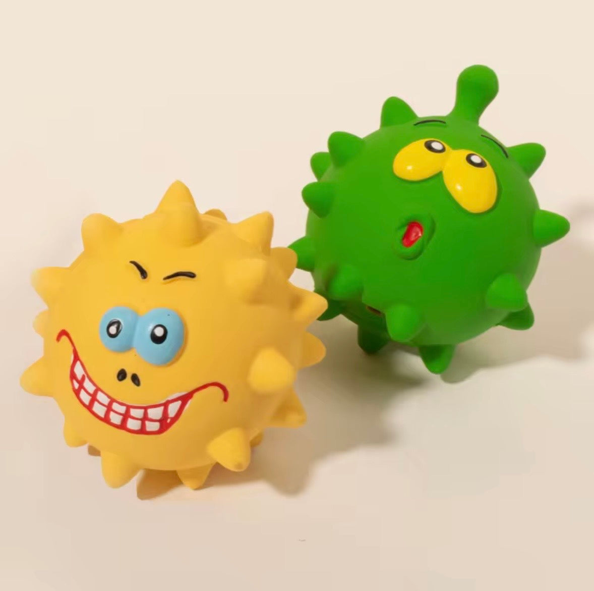 variety of spiky, colored dog chew toys and a dog wearing a pink and white shirt.